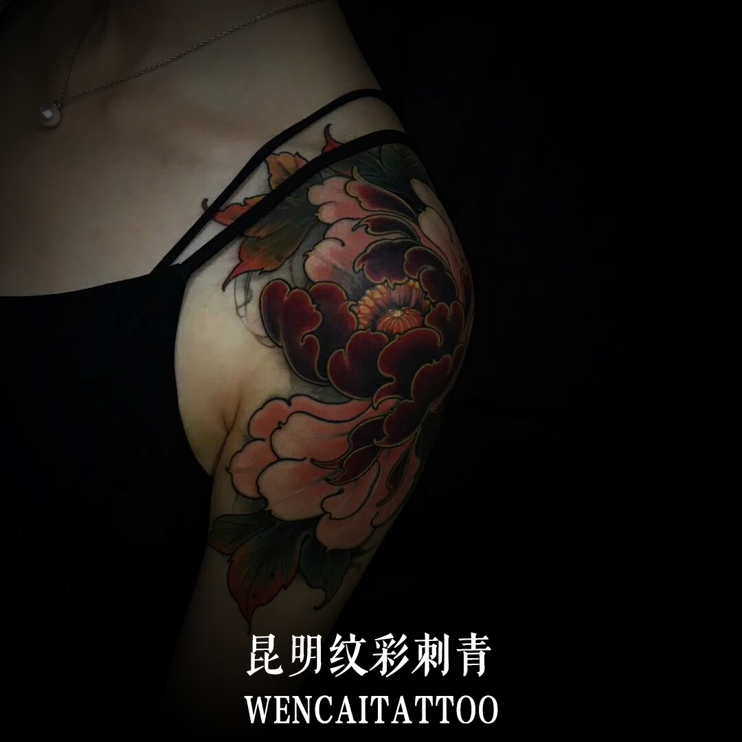 昆明的黄小姐大臂上的彩色花朵纹身图案